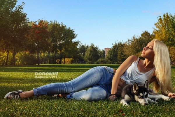 Blonde with husky lying in nature