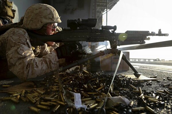 A soldier with a gun is lying on the ground