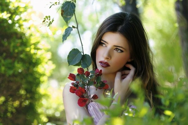 Morena con una flor en el bosque más a menudo