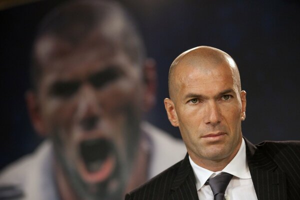 Zinedine Zidane in a jacket on the background of his photo