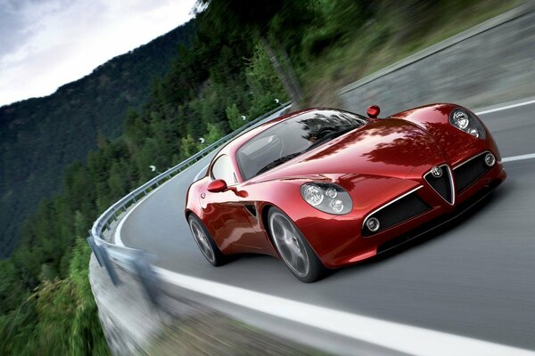 Alfa Romeo rojo en la carretera en las montañas