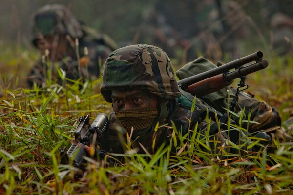 Soldados con armas disfrazados en la hierba