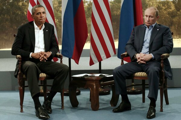 Traurige Barack Obama und Wladimir Wladimirowitsch Putin sitzen bei dem Treffen still