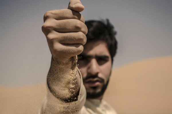 Sand fließt durch die Finger