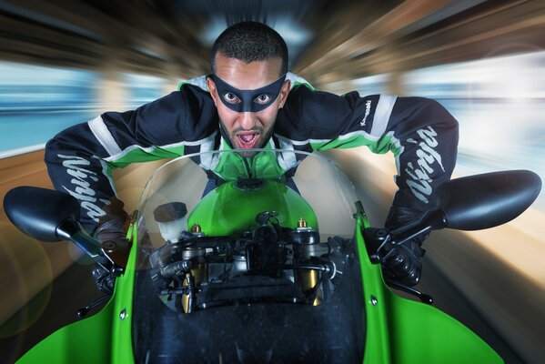 Foto di un pilota su una moto verde brillante