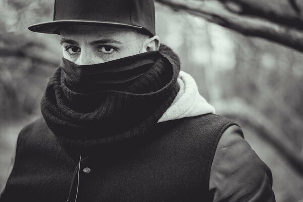 A young guy in a cap with his face covered