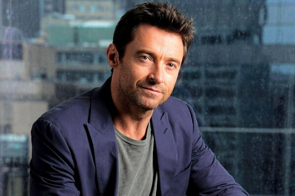 Hugh Jackman con un traje en el fondo de un rascacielos