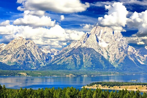 Clouds float across the sky over a mountain lake