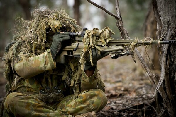 Ein Soldat in Uniform zielt aus einem Maschinengewehr