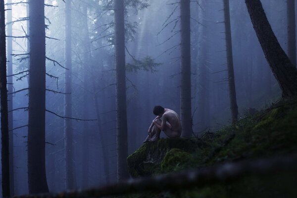 A naked man in a misty forest