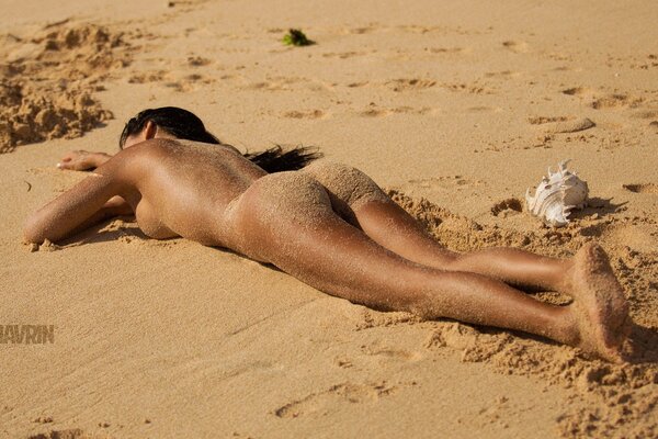 Hermosa chica tomando el sol en la playa