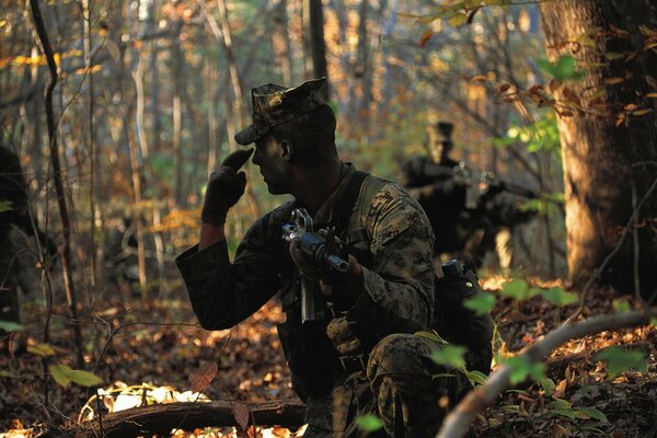 Ein Soldat im Wald mit einer Waffe sucht nach einem Ziel