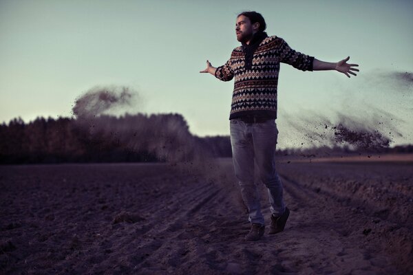 Photo of a guy walking on a field of land