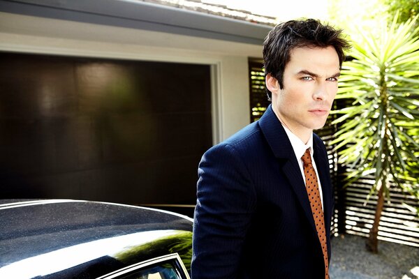 Actor in a black jacket and orange tie