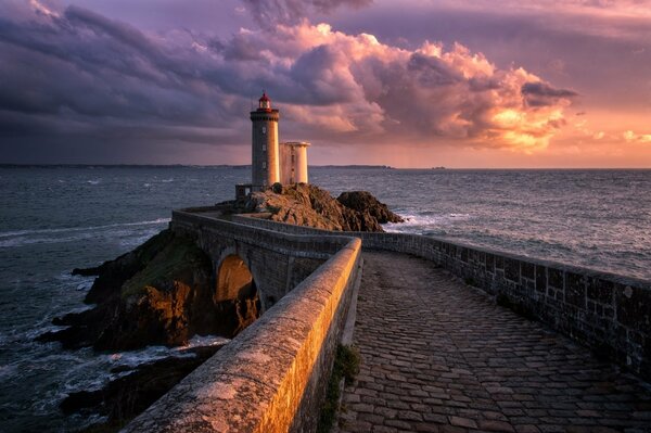 Faro in mare contro uno splendido cielo viola