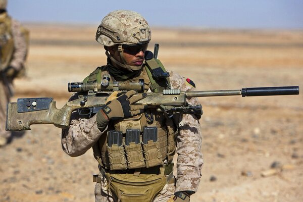 The US soldier presses the weapon tightly to the body