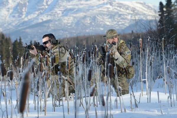 Soldados con armas en invierno. Montaña