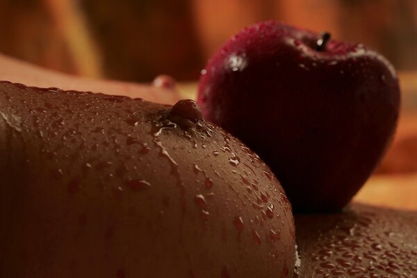 Roter Apfel und weibliche Brust