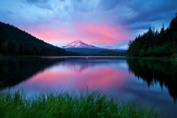La puesta de sol rosa se refleja en el agua azul