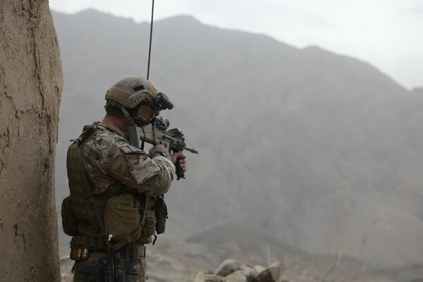 A soldier with a rifle in the mountains