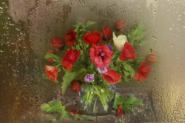 Bouquet on the table through the fogged glass