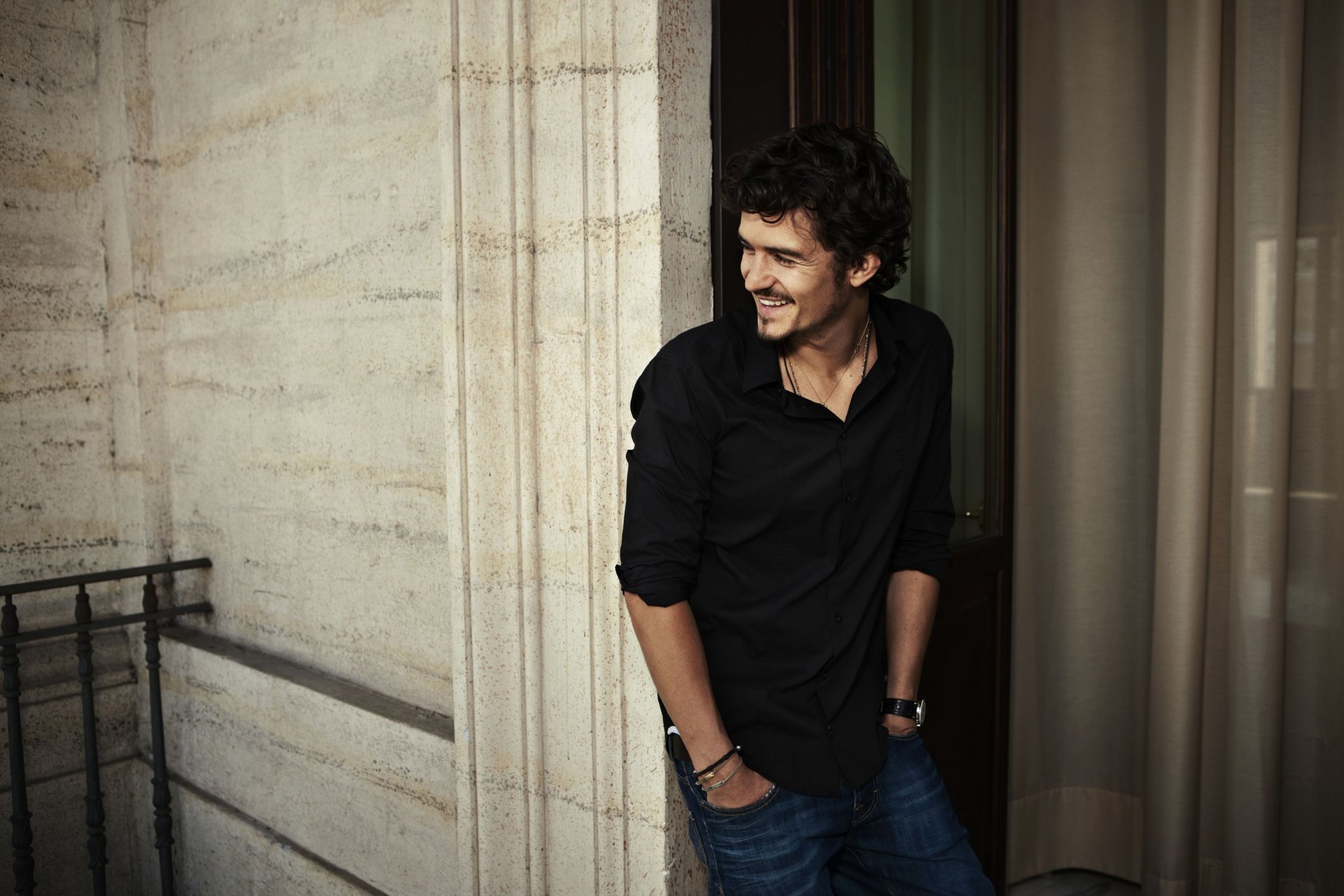 orlando bloom attore maschio celebrità bruna sorriso camicia nero jeans balcone