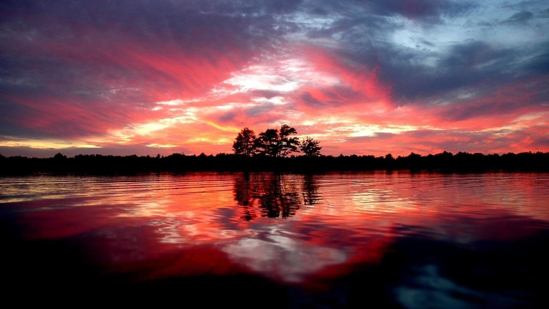 red sunset clouds trees water reflection