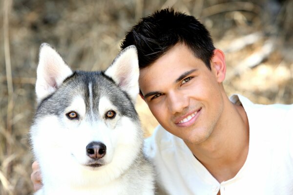 An actor with a smile and a serious dog