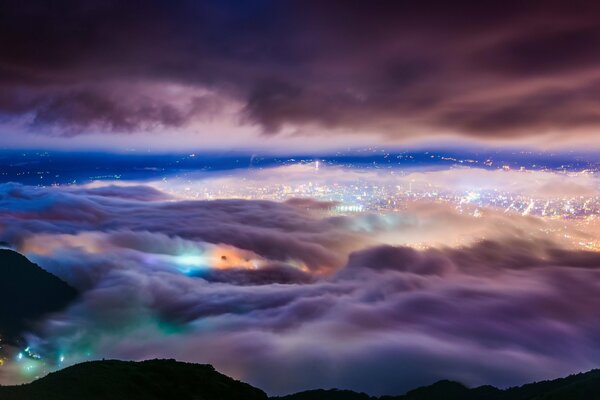 Flying over night clouds and city view