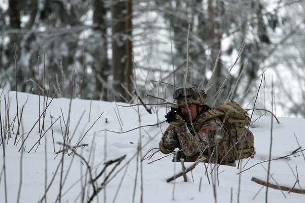 Soldat im Winterwald mit Waffen