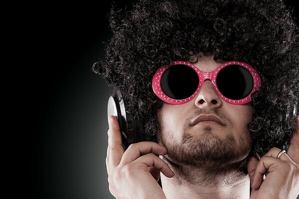 Curly-haired man with glasses and headphones