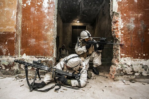 Soldaten in weißer Uniform schießen aus einem Maschinengewehr und einem Gewehr mit Zielfernrohr aus dem beschossenen Unterschlupf