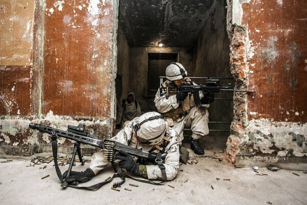 Żołnierze w białych mundurach strzelają zza wystrzelonej osłony z karabinu maszynowego i karabinu z lunetą