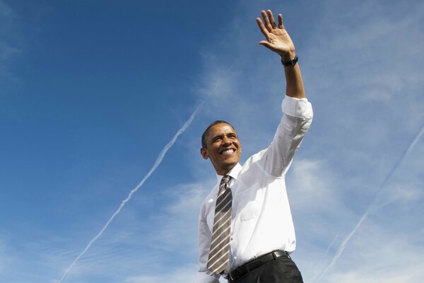 A smiling Barack Obama raised his hand in a welcoming gesture