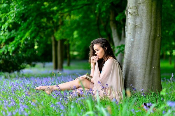 A thoughtful girl in a blooming meadow