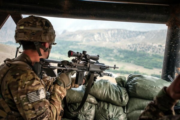 Soldado estadounidense en coche con rifle