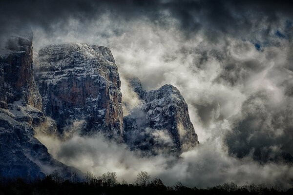 Hautes montagnes dans le brouillard et dans les nuages la nuit