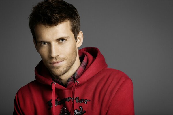 A guy with stubble in red clothes