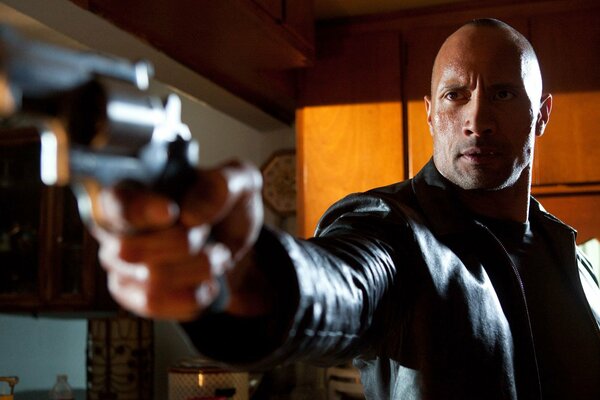 Actor in a leather jacket with a gun