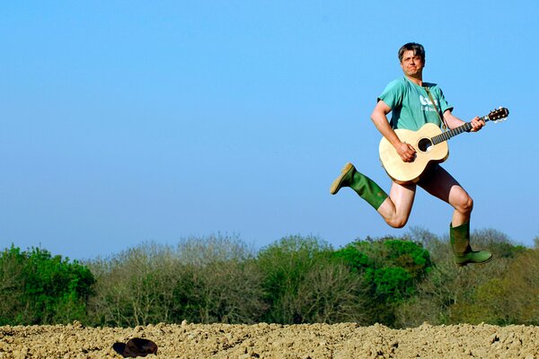 A man plays guitar in a jump