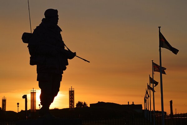 Silhouette of a military man with a gun at sunset