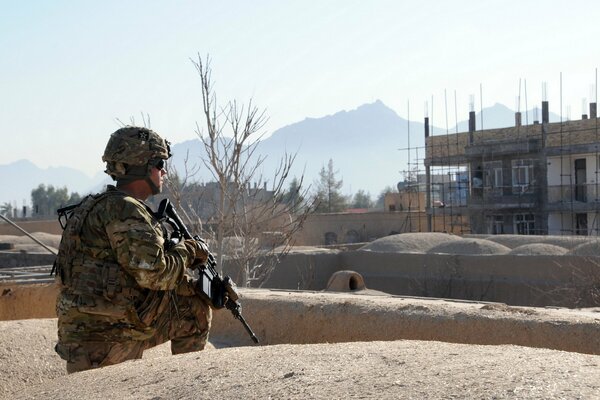 Soldat avec des armes sur fond de terrain désertique