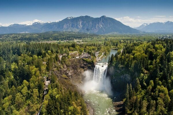 Impressive view of the waterfall from above among the mountains and forests