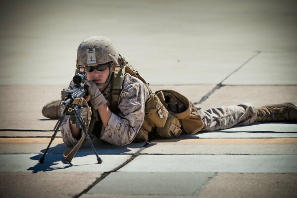 A soldier with a weapon is lying on a tile