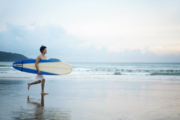 Ragazzo sulla spiaggia con una tavola da surf