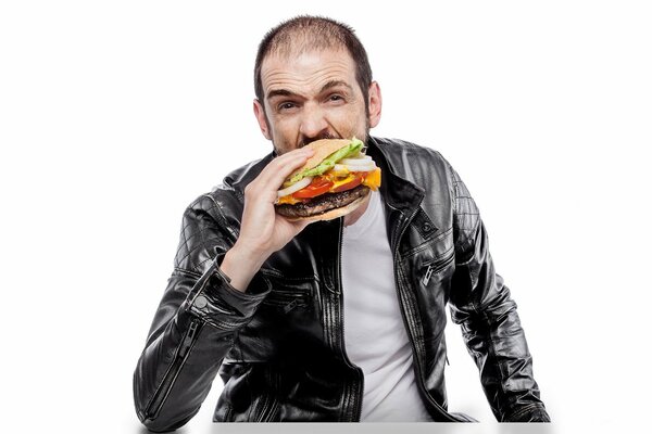 Мужчина в кожаной куртке есть гамбургер