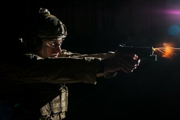 Un homme en uniforme tire une arme