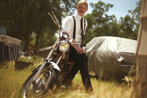 A man on a motorcycle in a field alone