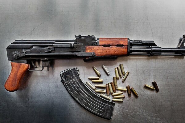 Kalashnikov assault rifle with cartridges on a metal background