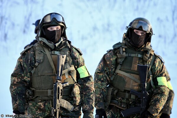 Commandos in camouflage and masks with weapons on a winter day